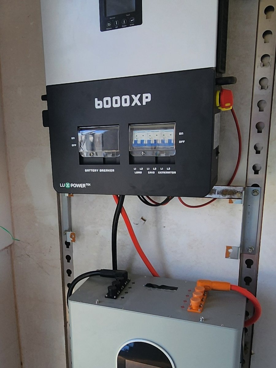 EG4 6000XP inverter mounted on a wall above an EG4 wall-mounted battery, wired and commissioned